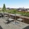 a patio with tables and chairs on it with a city in the background